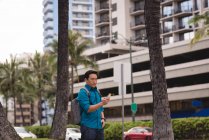 Розумний чоловік використовує мобільний телефон на міській вулиці — стокове фото