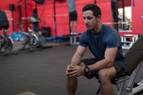 Спортсмен сидить на фізичних вправах у спортзалі — стокове фото
