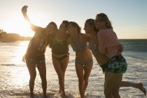 Женщины-волейболистки делают селфи с мобильного телефона на пляже — стоковое фото