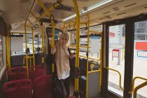 Mulher hijab bonita com telefone celular olhando para longe no ônibus — Fotografia de Stock