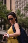 Bella donna utilizzando smartwatch in città — Foto stock