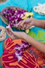 Mid section of woman preparing lei garland in the garden — Stock Photo