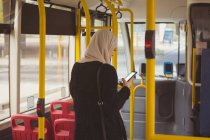 Красива міська хіджаб жінка використовує мобільний телефон в автобусі — стокове фото