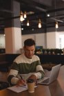 Empresário escrevendo em um diário na cafetaria no escritório — Fotografia de Stock