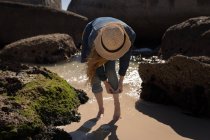 Женщина складывает штаны на пляже в солнечный день — стоковое фото