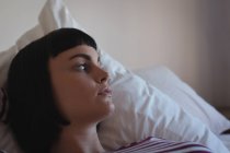 Mujer preocupada relajándose en el dormitorio en casa - foto de stock
