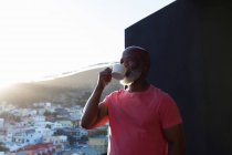 Senior man having coffee in balcony at home — Stock Photo