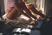 Junge Frau benutzt Laptop im heimischen Wohnzimmer — Stockfoto