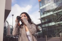 Mulher clicando foto com câmera digital na cidade — Fotografia de Stock