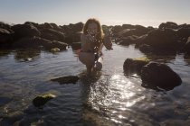 Glückliche Frau im Bikini spielt mit seichtem Wasser — Stockfoto