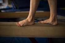 Sportswoman bilanciamento su barra di legno in palestra — Foto stock