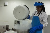 Científica hembra abriendo tapa de máquina en laboratorio - foto de stock