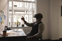 Progettista grafico senior che utilizza cuffie realtà virtuale in ufficio — Foto stock