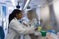 Побічний погляд на експеримент жінки-вченого в лабораторії — стокове фото