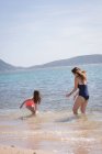 Mãe e filha se divertindo na praia em um dia ensolarado — Fotografia de Stock