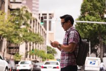Розумний чоловік використовує мобільний телефон на міській вулиці — стокове фото