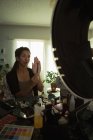 Красивая женщина блоггер видео держа косметический аксессуар дома — стоковое фото