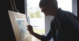 Вид збоку на жінку художника картина на полотні вдома — стокове фото