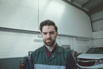 Porträt eines selbstbewussten Mechanikers, der in der Garage steht — Stockfoto