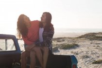 Casal de romances em uma caminhonete na praia — Fotografia de Stock