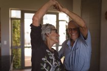 Beau couple senior dansant ensemble à la maison — Photo de stock