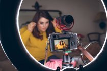 Registrador de vídeo feminino aplicando maquiagem em casa — Fotografia de Stock