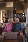 Romantic senior couple kissing each other in living room at home — Stock Photo