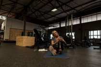 Femme mature handicapée avec prothèse de jambe dans la salle de gym — Photo de stock