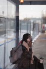 Молода жінка розмовляє по мобільному телефону на станції метро — стокове фото