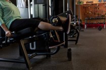 Mujer discapacitada haciendo ejercicio en la máquina en el gimnasio - foto de stock