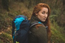 Portrait of beautiful female hiker with backpack looking into camera — Stock Photo