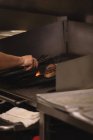 Männlicher Koch kocht Fleisch im Grill in der Küche — Stockfoto