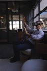 Empresario con auriculares de realidad virtual en la oficina - foto de stock