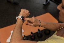 Partie médiane de la femme utilisant smartwatch dans la salle de gym — Photo de stock