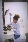 Жінка-фотограф знімає котушку з цифрової камери в фотостудії — стокове фото