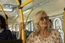 Pensativa mujer mayor viajando en el autobús - foto de stock