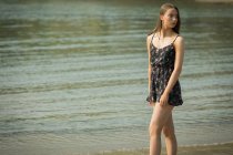 Bella donna in piedi sulla spiaggia in una giornata di sole — Foto stock