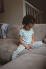 Дівчинка сидить на дивані і вдома за допомогою цифровий планшетний — стокове фото