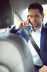 Бізнесмен розмовляє на мобільному телефоні в сучасній машині — стокове фото