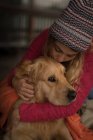 Девушка целует собаку дома — стоковое фото