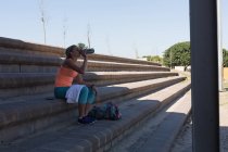 Жінка-спортсменка п'є воду на спортивному майданчику — стокове фото