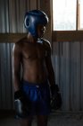 Задумчивый боксер, стоящий в фитнес-студии — стоковое фото