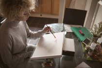 Jeune femme colorier un croquis à la maison — Photo de stock