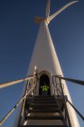 Engenheiro de pé na entrada de um moinho de vento em um parque eólico — Fotografia de Stock