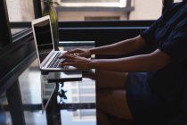 Mittelteil der Geschäftsfrau sitzt und benutzt Laptop im Büro — Stockfoto