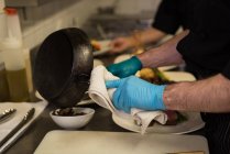 Чоловічий шеф-кухар, який подає їжу в мисці на кухні — стокове фото