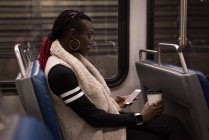 Junge Frau benutzt Handy während Zugfahrt — Stockfoto
