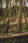 Молода жінка мандрівного ходьба на стовбурі fallen дерево у лісі — стокове фото