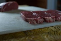 Close-up de carne arranjada em tábua de corte no talho — Fotografia de Stock