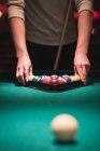 Mann arrangiert Snookerbälle im Dreiecksgestell eines Nachtclubs — Stockfoto